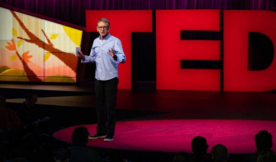 A man, John Doerr, speaking on stage at a TED event