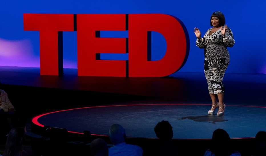 A woman, Bevy Smith, speaking on stage at a TED event