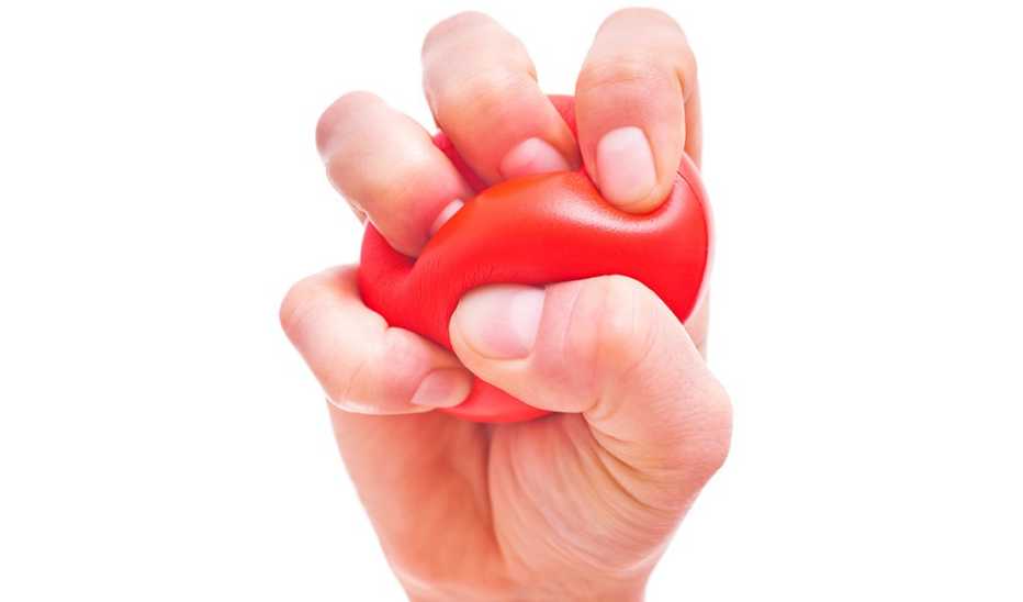 A close-up view of a hand squeezing a stress ball
