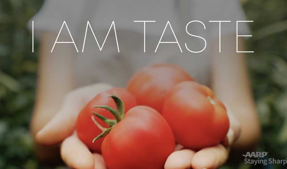 An up-close view of hands holding tomatoes with "I Am Taste" text