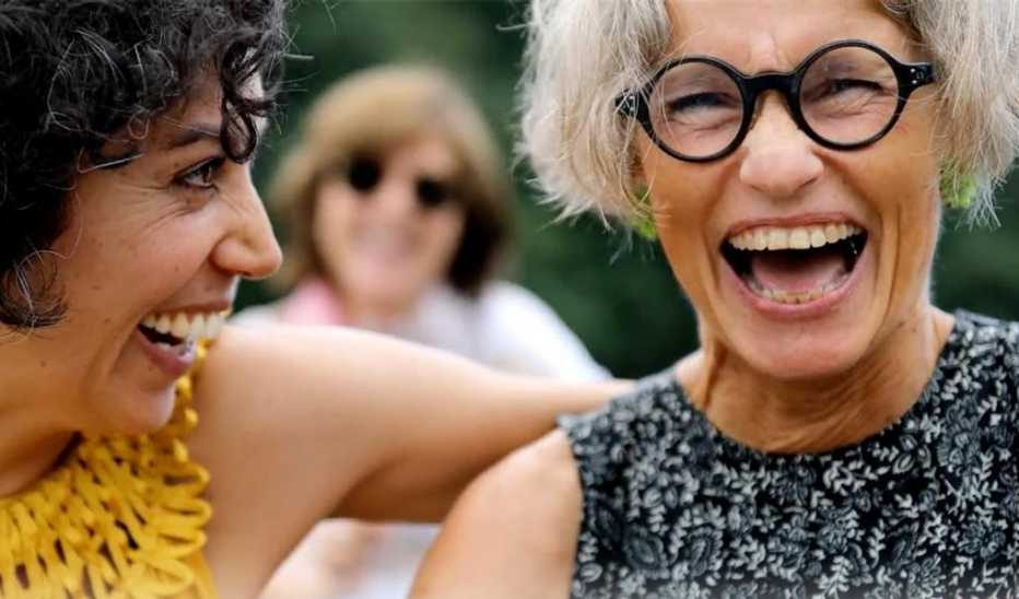 An up-close view of two women smiling and laughing together